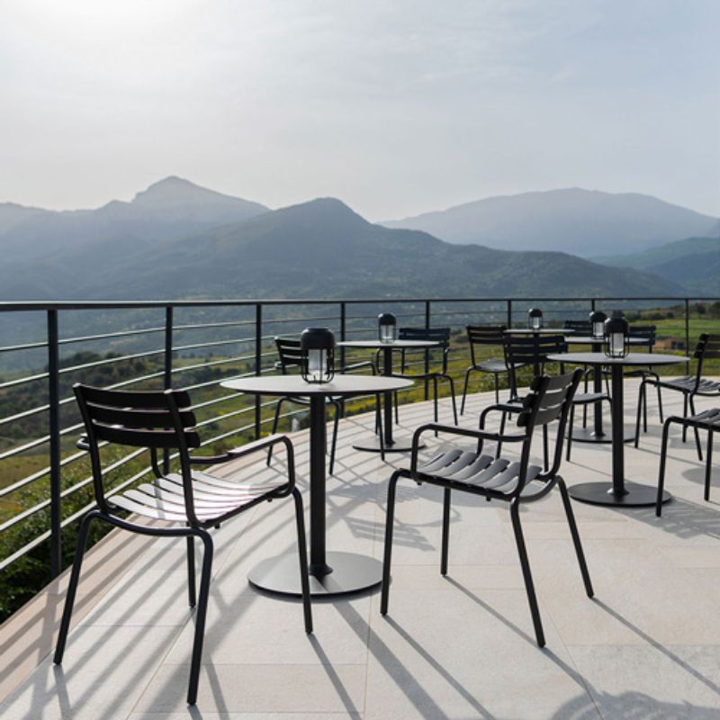 Moderne Outdoor-Leuchten auf Terrassentischen mit Metallmöbeln, ideal für Gastronomie und Außenbereiche mit Panoramaausblick