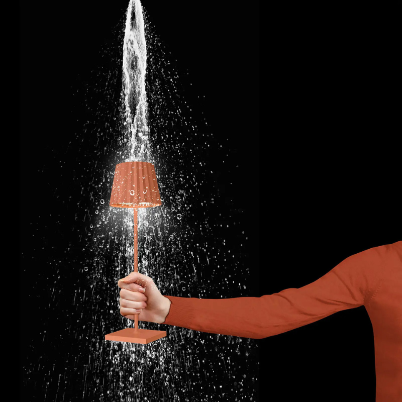 Sompex LED Outdoor Lampe Troll in Orange in einer Hand mit Wassertropfen (Outdoor geeignet)